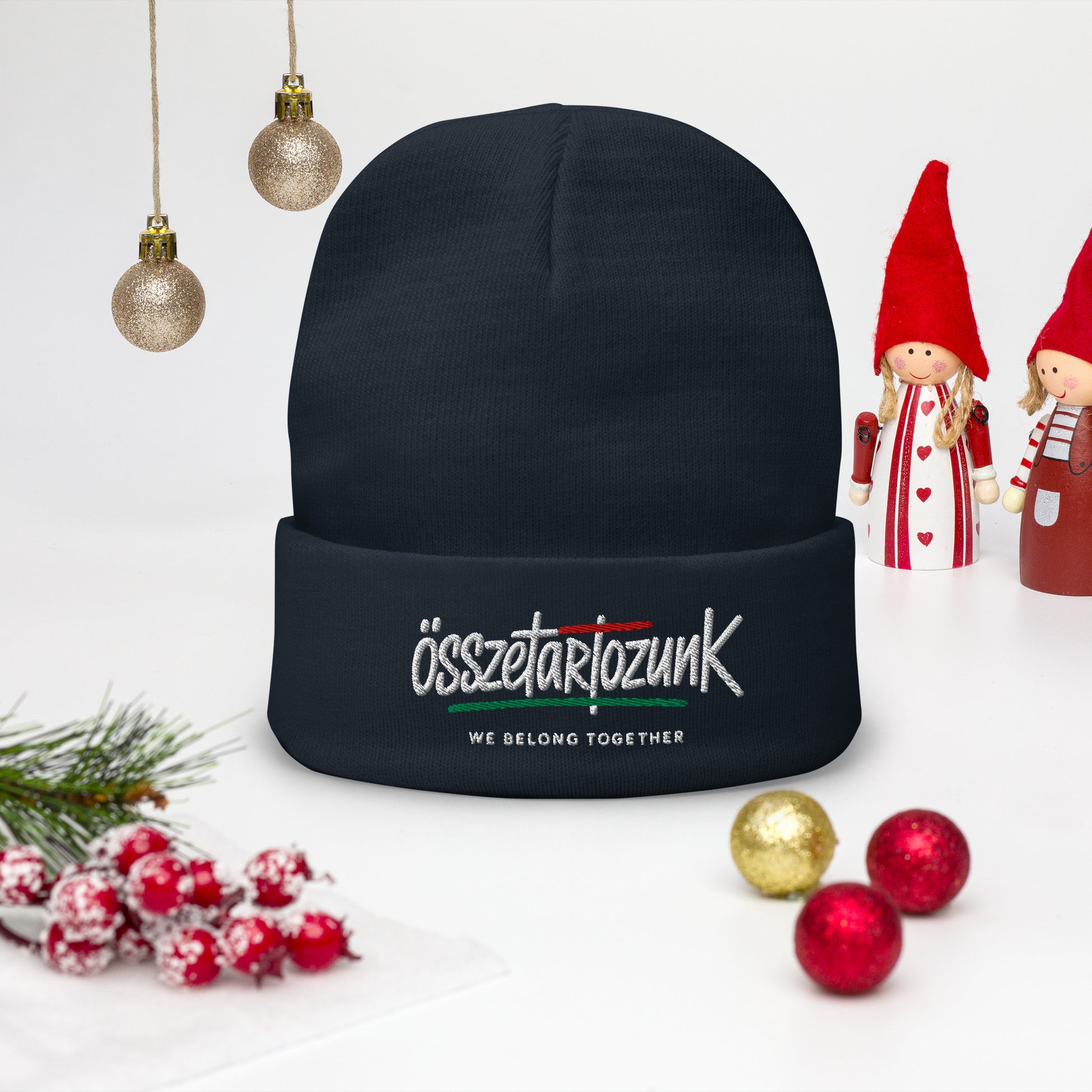 Black beanie with text, Christmas decorations, and small figurines on a light background